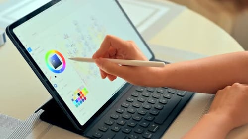 Woman drawing on a tablet with white pencil, close up