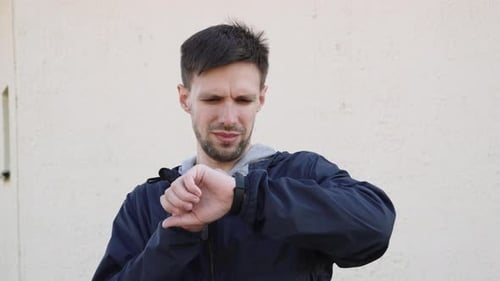 Man Checks Smartwatch Device Outdoors