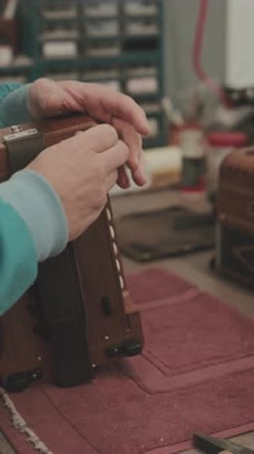 Hands opening concertina accordion instrument in workshop vertical