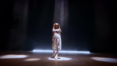Young Woman Dancing Under Stage Lights
