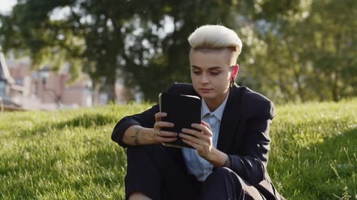 Young Adult Using Tablet in an Urban Park