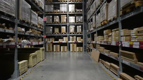 Wide angle view of tall racks in a large industrial warehouse