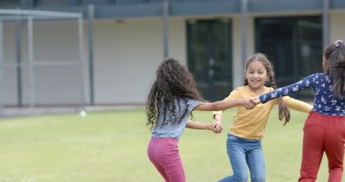 School playground is full of joy with three biracial girls playing, with copy space
