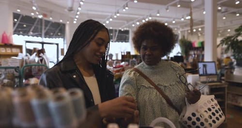 Female Shoppers Browsing Yarn On Display In Craft Store Slow Motion