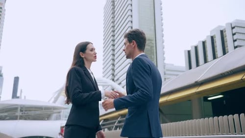 Caucasian businessman and businesswoman handshake outdoor in the city. Attractive team of employee w