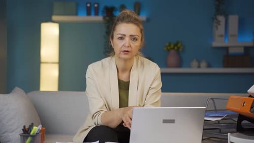 Home office worker woman looking at camera depressed.