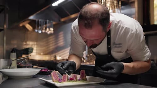 Chef is Plating Breaded Tuna Fish Fillets in Kitchen of Restaurant