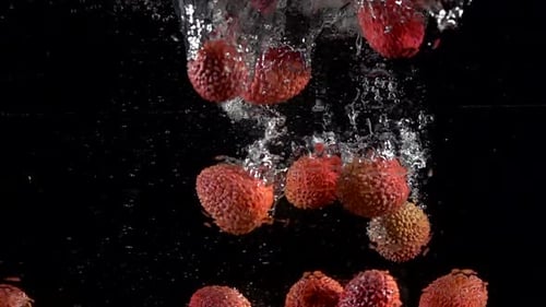 Lychees Falling Into Water in Slow Motion
