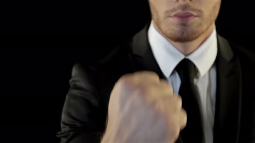 Man in Suit Makes Fist Gesture