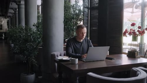 Freelancer utilisant un ordinateur portable et travaillant à distance dans un café de la ville Portrait d'un jeune homme d'affaires adulte