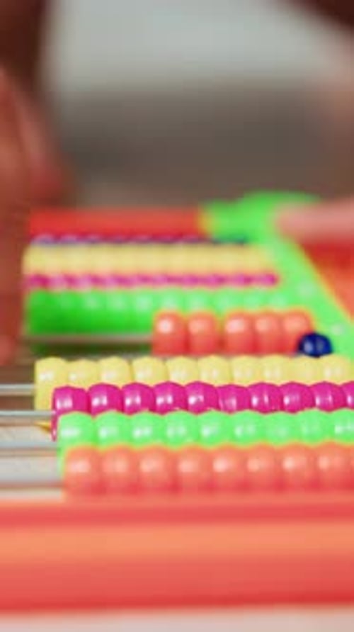 Small Fingers Skillfully Slide Vibrant Beads in Educational Setting Highlighting Early Learning