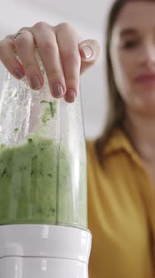 Frau, Hand und Mixer mit grünem Saft oder Smoothie in der Küche für Ernährung, Vitamine oder Diät