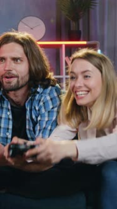 Excited couple plays video game together in cozy home