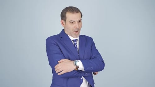 Skeptical Man in Blue Suit Stands with Arms Crossed
