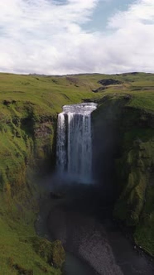 Aerial View of Skogafoss Waterfall with Lush Green Cliffs in Iceland