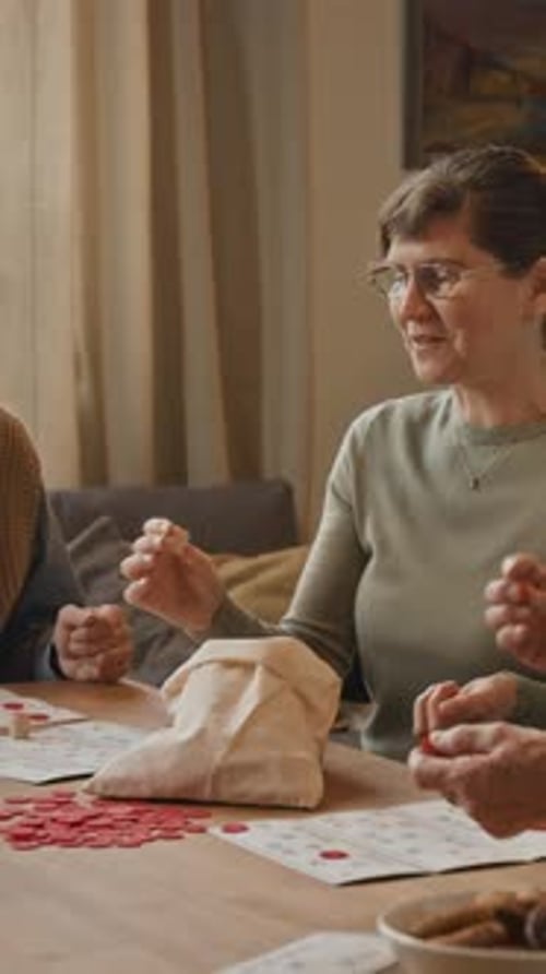 Seniors Playing Bingo Together at Table in Home