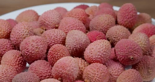 Rotationshintergrund mit exotischen Früchten aus Litschi. Geerntete Litschifrüchte oder Beeren. Asiatisches Essen