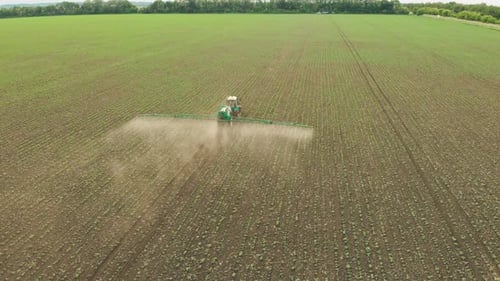 Aerial View of the Tractor That Irrigates the Green Field By Special Installation Processing of a