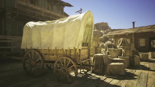 La luz del sol resalta la escena de un antiguo vagón junto a un pozo de agua