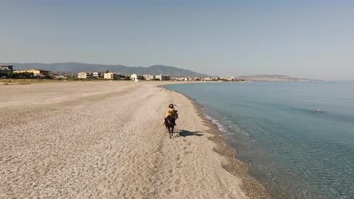 Woman Rides By the Ocean