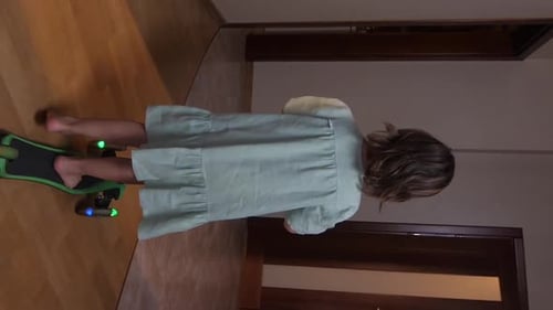 Vertical Video Girl Riding a Scooter Around the Apartment Girl Learns Scooter