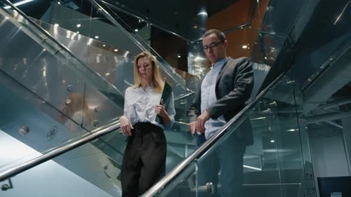 Closeup View of Man and Woman Walking Down the Stairs in Modern Business Centre