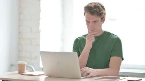 Man Typing on Laptop Computer at Desk