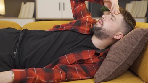 Man Lies on Couch Using Smart Phone
