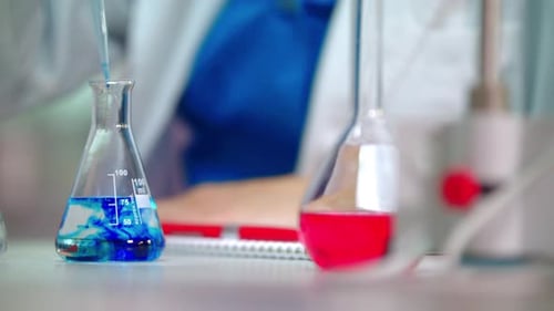 Clinical Testing. Lab Experiment in Glass Flask. Pouring Blue Reagent in Pure