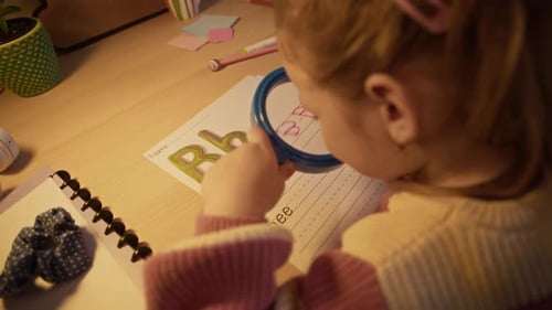 Girl Using Magnifying Glass to Examine Letter Tracing Worksheet