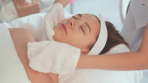 Relaxed Woman Receiving Facial Treatment at Beauty Spa