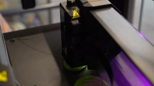 3D printer in action creating an object from molten plastic