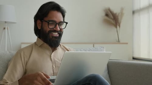 Bearded Man Using Laptop for Video Call at Home