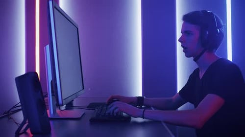 Young man plays online video game in colorful room