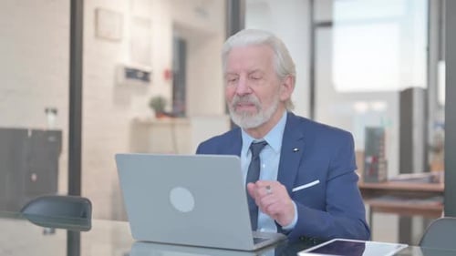 Senior Man Attending Virtual Conference Using Laptop