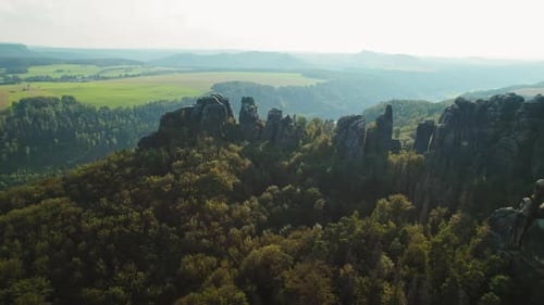 Aerial view of forested rock formations in Schrammsteine Elbe Sandstone Mountains under a clear sky