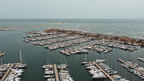 Meer und Hafen aus der Drohnen-Luftaufnahme. Verschiebende Bewegung, um Docks mit vielen Booten zu sehen.