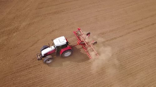 Tractor Tilling Soil in Expansive Farm Field