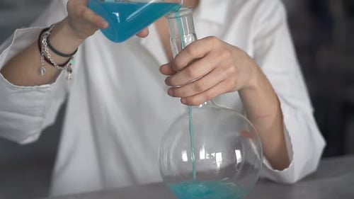 Wissenschaftlerin im Teenageralter mischt Chemikalien in einer Flasche,