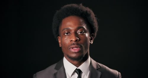 Bekannter afrikanischer Künstler und Musiker, der die Essenz des Handwerks durch intensiven Blick einfängt, eleganter Anzug