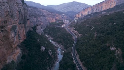 Eine Straße überquert einen Berg mit einem Fluss daneben