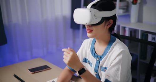 Young Adult Uses VR Headset at Desk