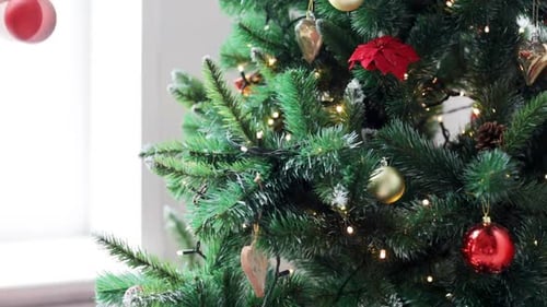 Winter Holidays, Celebration And People Concept - Woman Decorating Christmas Tree With Ball