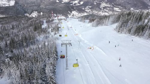 Aerial View of a Ski Lift with Skiers and Snowboarders on a Snowy Slope