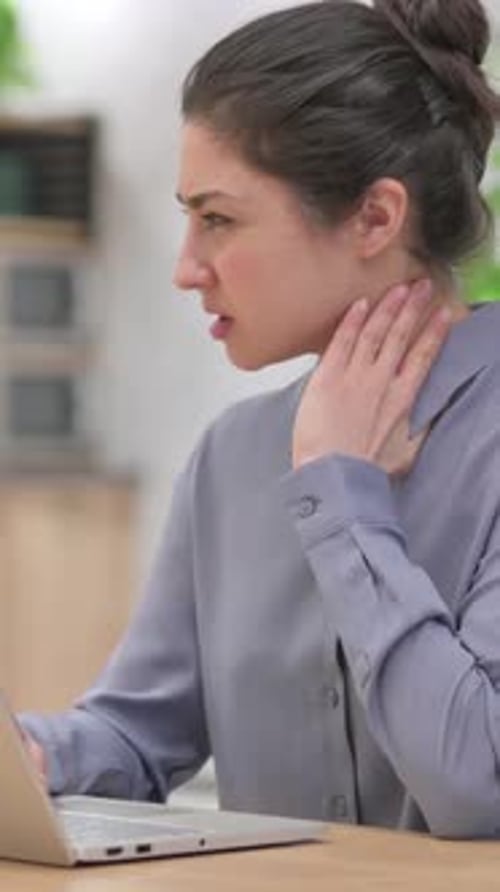 Young Woman Typing and Suffering From Neck Pain