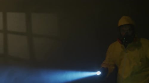 Hazmat suit-wearing man explores a smoky room