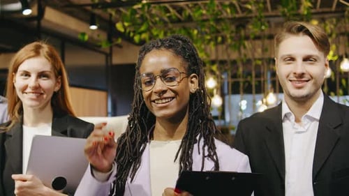 Multiracial Team of Business Professionals Stands in a Row Smiling Confidently for a Corporate