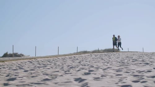 Cheerful Elderly Wife and Husband Running Along Path on Seashore