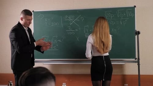 Teacher Explains Math to Student in Classroom