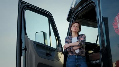 A Woman Trucker Stands in a Semi Truck Close Up Shot